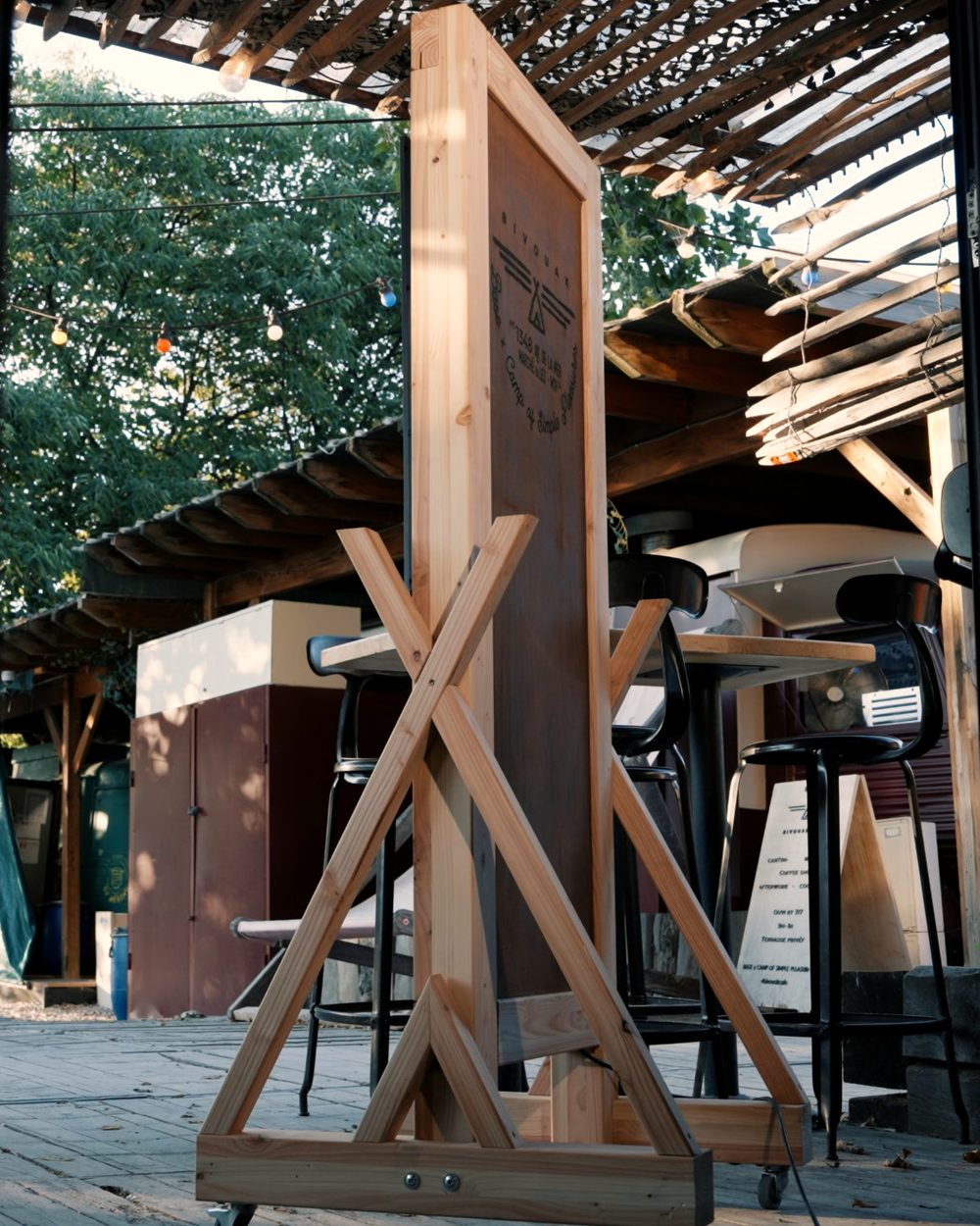 Kakémono digital Bivouak en bois massif, piétement en tipi, sur la terrasse du lieu